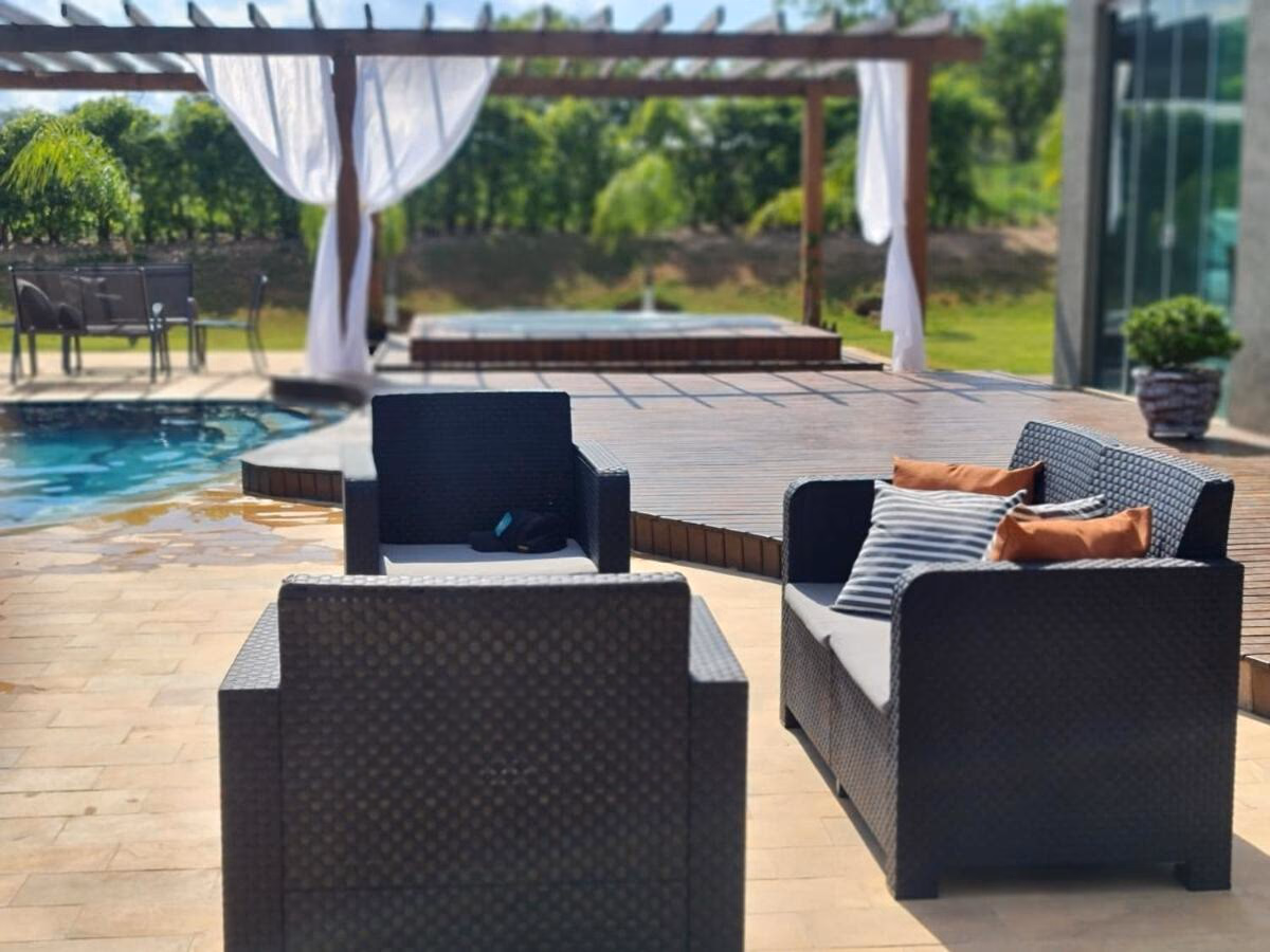 Lounge externo com poltronas de fibra sintética à beira da piscina