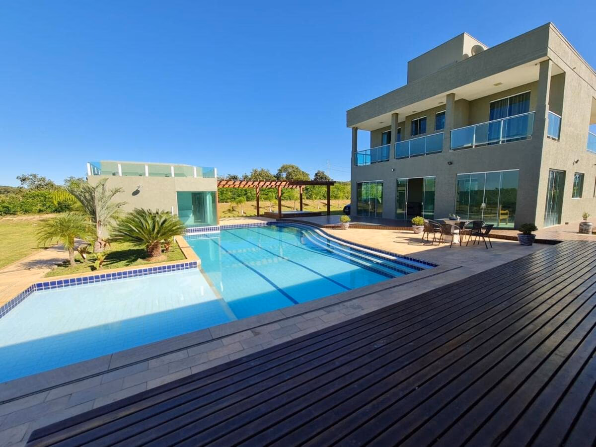 Fachada da Mol Residence vista do deck, com piscina em primeiro plano e sobrado ao fundo