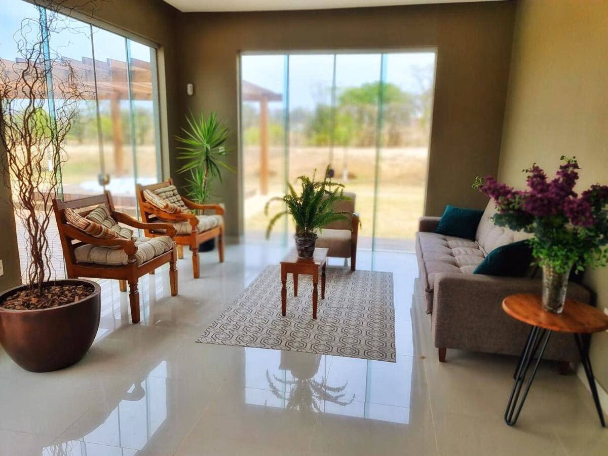 Poltronas de madeira e estampas listradas na sala de estar
