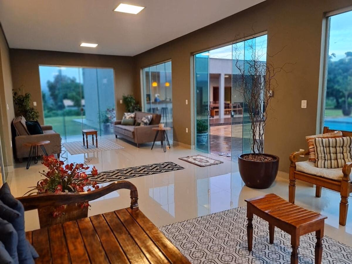 Portas de vidro do living abrindo para o deck e o jardim