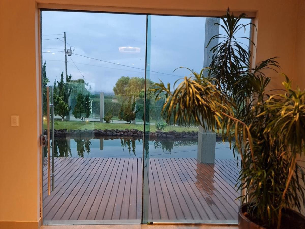 Vista da porta de vidro para o deck e o lago ornamental ao entardecer